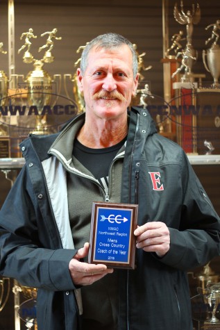 Frank Dauncey, Cross Country Head Coach, holding up his second award of recognition as "Regional Coach of the Year." 