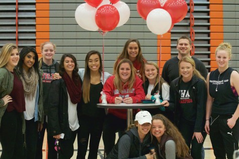 Lauren Allison with all of her friends from the soccer and basketball team, along with her soccer coach Geoff Kittles joining for a group photo, after Allison signed her letter of intent to Saint Martin’s University in the Walt Price Fitness Center on Wednesday afternoon. 