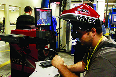 EvCC student Caleb Mathis practicing welding on Virtual Reality Training Simulator-VRTX 360 at the AMTEC grand opening.