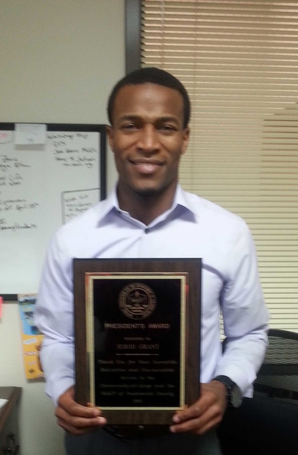 Jerod Grant with the NAACP President award in his office at the Outreach and Diversity Center oer at Parks and Student Union.