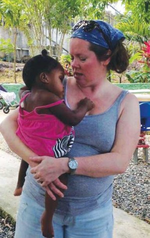 Former student Kimball Conlon singing to Genesis, a child with Spina Bifida, a birth defect which affects the spinal cord, at a children's home in the Dominican Republic. Genesis, the wheelchair bound girl is enjoying the physical touch and love by snuggling right in.