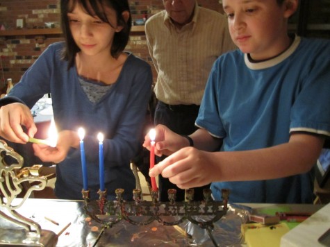 Molly and her brother lighting their menorah.