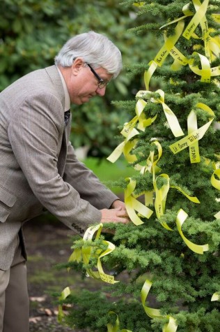 Dale Galloway, EvCC instructor and Veterans Club Advisor places a ribbon on the ceremonial tree. 