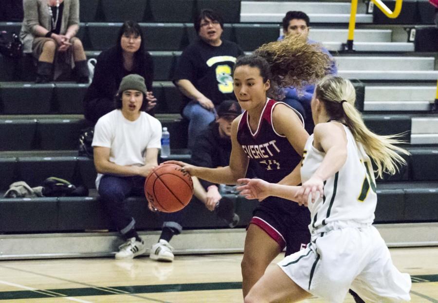 Trojan Guard Riley Zucker driving to the hoop against Shoreline Freshman Dani Hayes looking to keep EvCC on top.