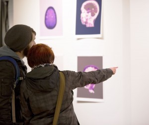 Two students looking at some of Daisy Patton's artwork at the Russell Day Gallery. Patton's artwork brings light to her MS. 