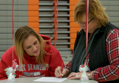 Mayrene Allison signing the Letter of Intent after her daughter, since Allison is not 21 her mother had to co-sign the document.