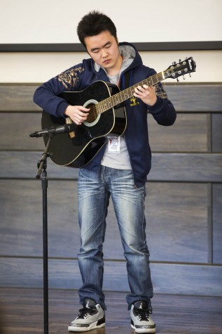 EvCC Chinese student, Zhonhni Yong, performing for the audience by playing his guitar.