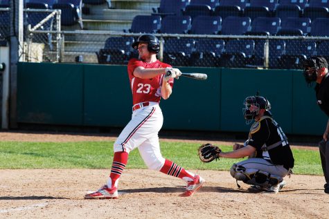 Keeping his head in tight, Jake Nelson hits a single into the outfield during the Trojans game against Douglas College.