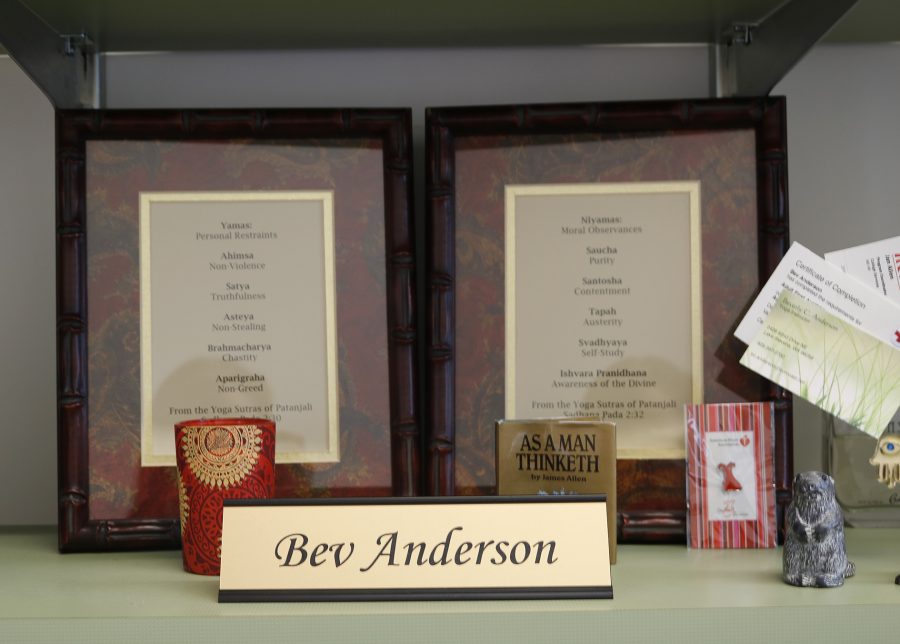 Beverly Andersons name plate in front assorted things on her desk.