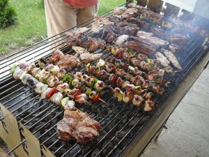 A barbecue cooking tons of good food in the backyard during summer time. 