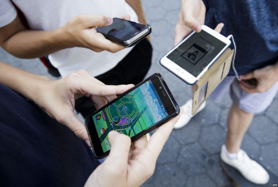 People playing Pokémon GO. Once the app was released, it became extremely popular. It is the biggest mobile game in U.S. history and became the top grossing application in the U.S. within 13 hours of its release according to Touchstone Research Innovation & Excellence. 