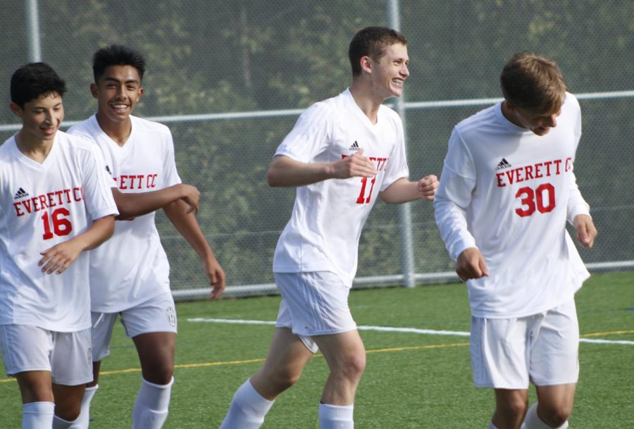 Teammates Siloe Galvan (#16) , Henry Gonzalez (# 15), and Ethan Millholland  (#30) celebrate victory with Gregor Byrne (#22) against Shoreline on Oct 6. EvCC won the match 4-1.