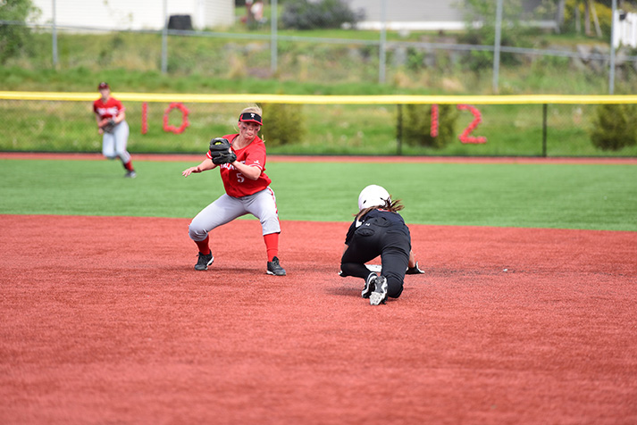 Megan+Dedrick+looks+to+tag+a+runner+sliding+in+to+second+base.