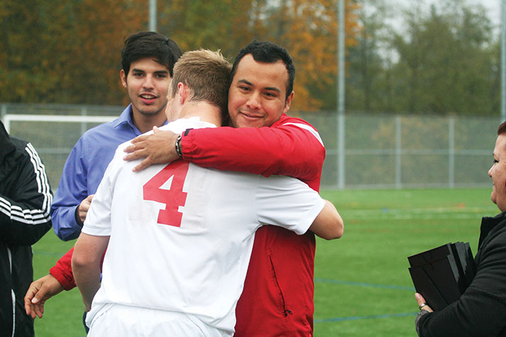 Erik Cruz embraces Trojans defender Steven Zeka in a prematch
ceremony on Sophmore Day in the 2017 season.