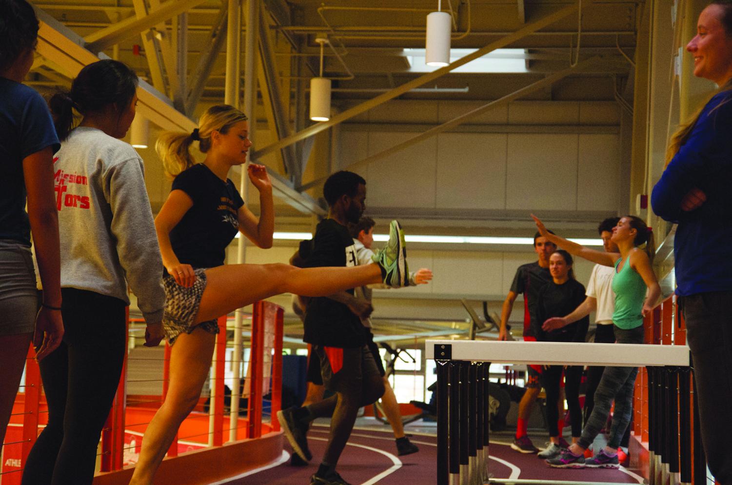 Kicking it during warm up drills with Kaitlin Morgan (left).
Coach Tansey Lystad (right foreground) leads cross country practice on Monday Oct. 8 at the Walt Price Student Fitness Center.