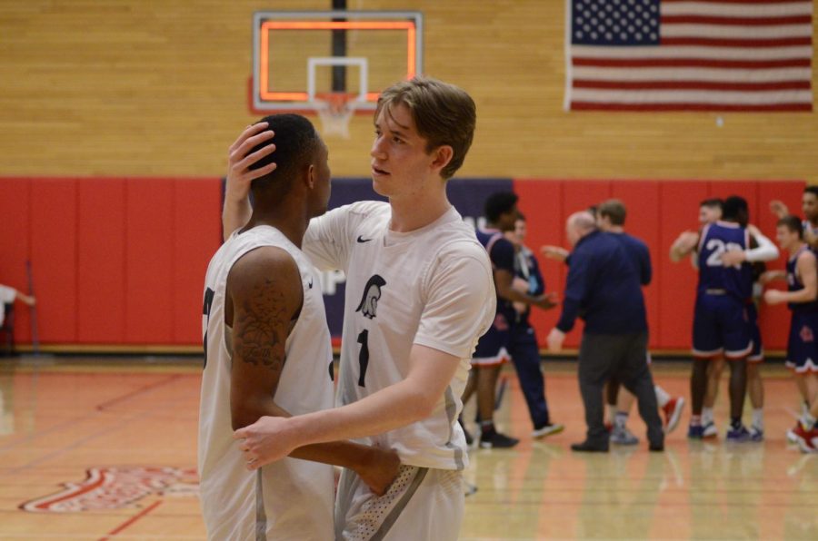 Trojans teammates Tori Odom (left) and Jon Parker (right) comfort one another as the Red Devils celebrate in the distance after the final buzzer in Thursday night’s season-ending tournament loss to Lower Columbia College.