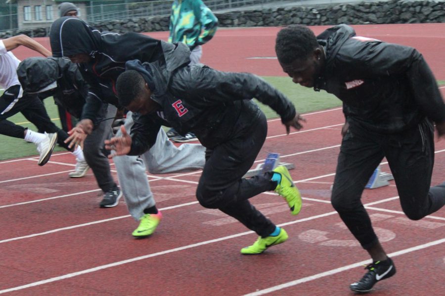 Dimeji Adekanbi (second from right) runs the 100 meter at track practice.