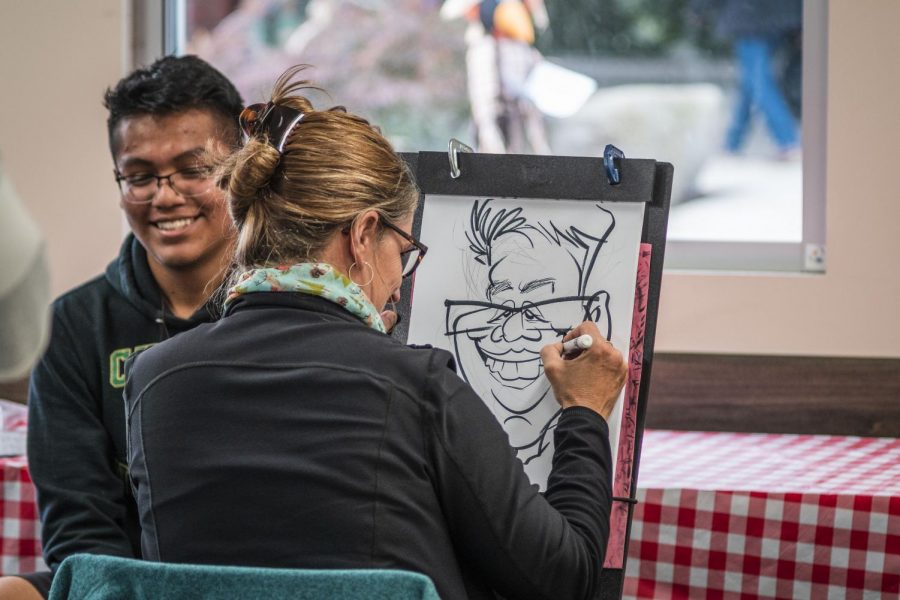 EvCC student receives a caricature during Fall Fest 2019.