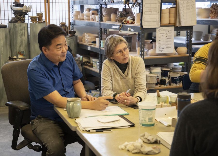 Ceramics instructor, Thom Lee (left), working with student Ann Morgan and others in the ceramics classroom located in White Horse Hall.