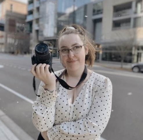 EvCC alumna, Katja Wahl,  photographed with a camera in hand prior to contracting COVID-19.