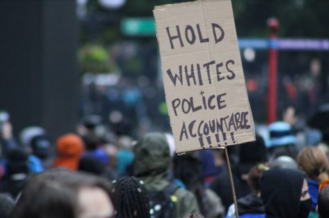 Black Lives Matter protester holds a sign saying