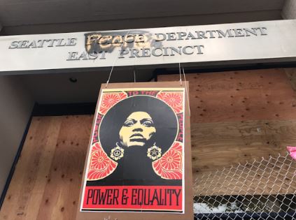 The abandoned Seattle Police Department East Precinct on Capitol Hill, defaced as the "Seattle People Department East Precinct" decorated with a sign that reads "Power & Equality".