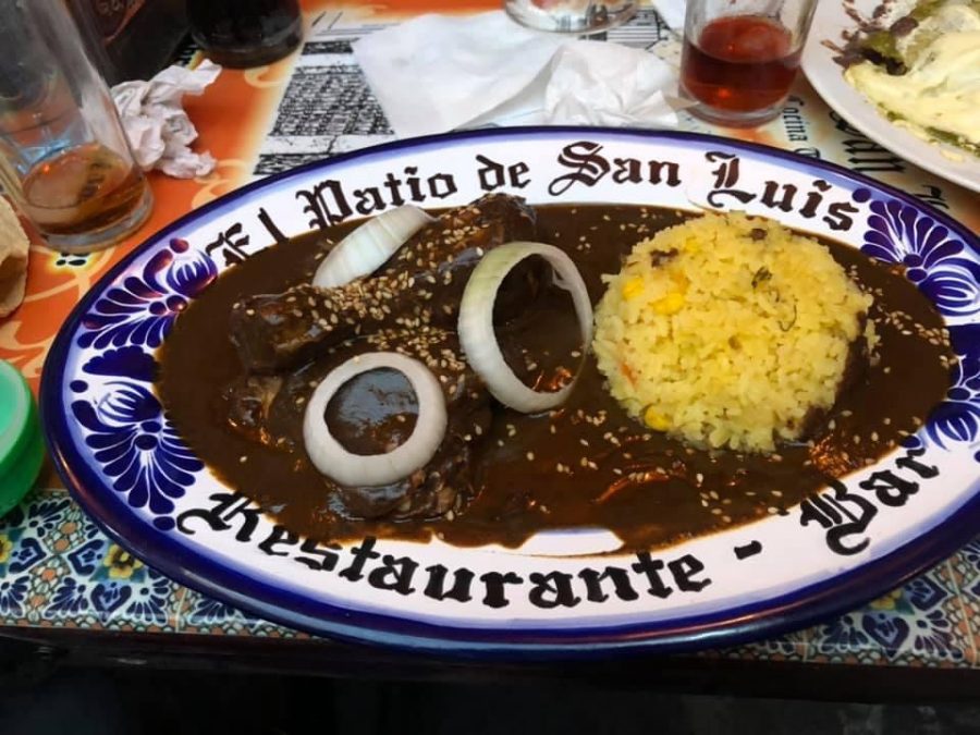 Mole poblano, a rich sweet and spicy sauce made of a variety of chiles poblanos served over chicken and accompanied with a bed of rice on the side.