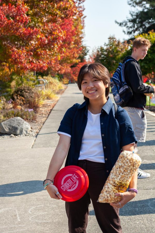 Student Theresa Van stands with her kettle corn and frisbee which she received for attending the Student Life Trojan Kick-off event.
