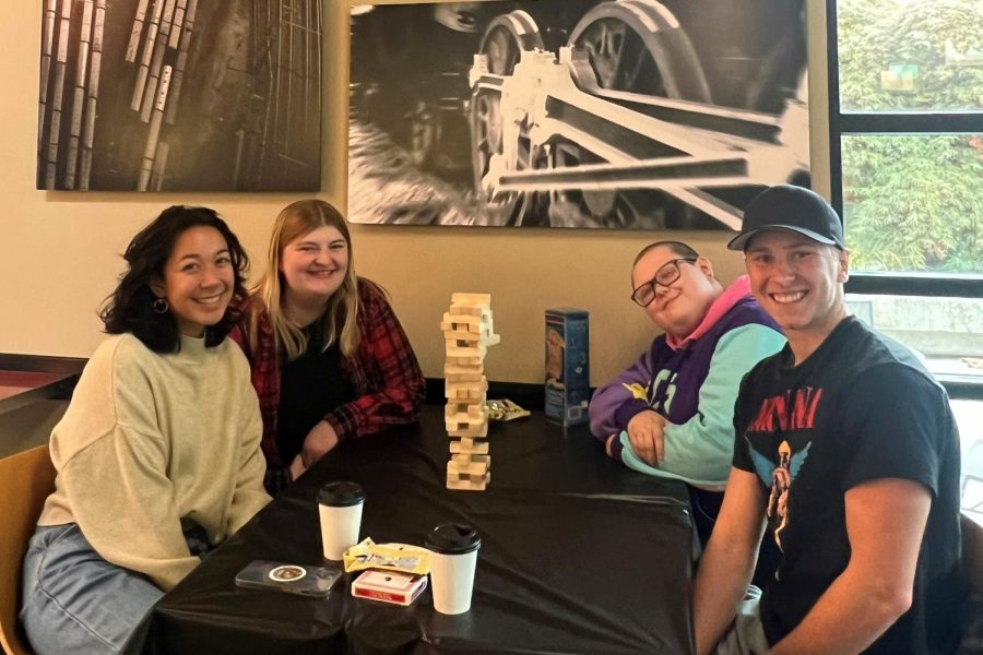 Katarina Santos (near left), Nikki Duell (far left), Elijah Broughton (far right) and Luke Joss (near right) all playing games after going to the Cafecito con Pan event.
