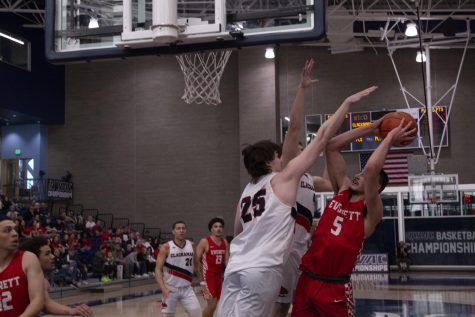 Redshirt freshman Tucker Molina goes up through two Clackamas defenders. Molina put in a strong defensive effort with six rebounds and two blocks.