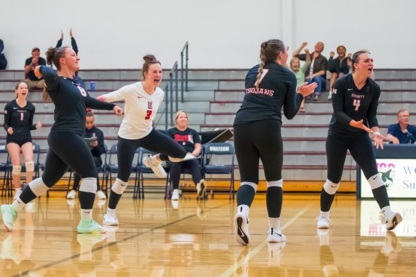 The squad all celebrate after scoring a point in there match with Highline. Sophomores Deanna Gibb (Left), Camille Clark (Left Center), Katie Serles (Right Center), and Malia Shepherd (Right) all have been key players for the Trojans this season. 