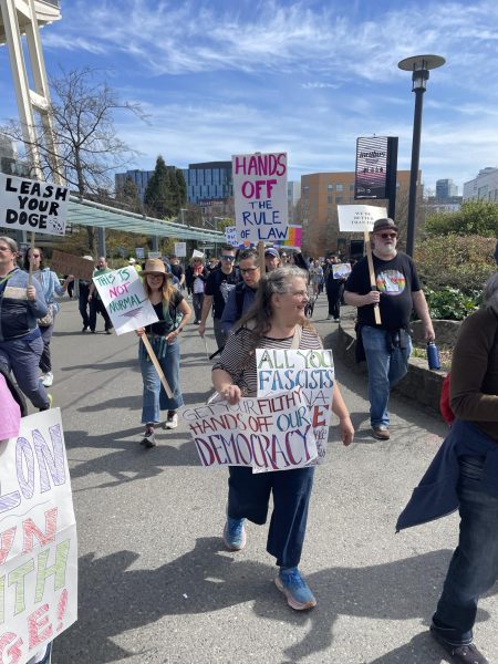 Luckily, the weather was clear and sunny for the protesters holding signs at Seattle "Hand's Off!" march.