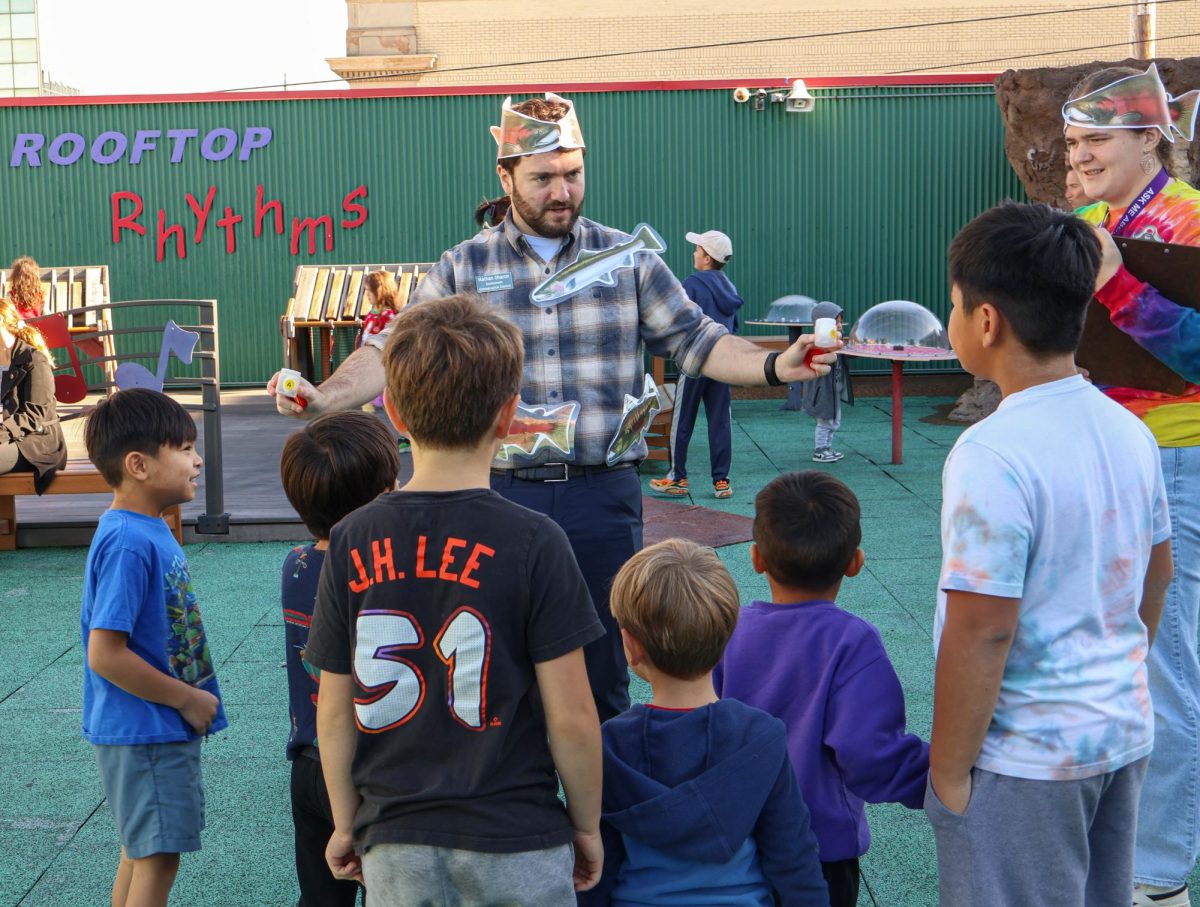 By searching for the scent in the cup in the rooftop park, children learn that salmon track their home by smell.