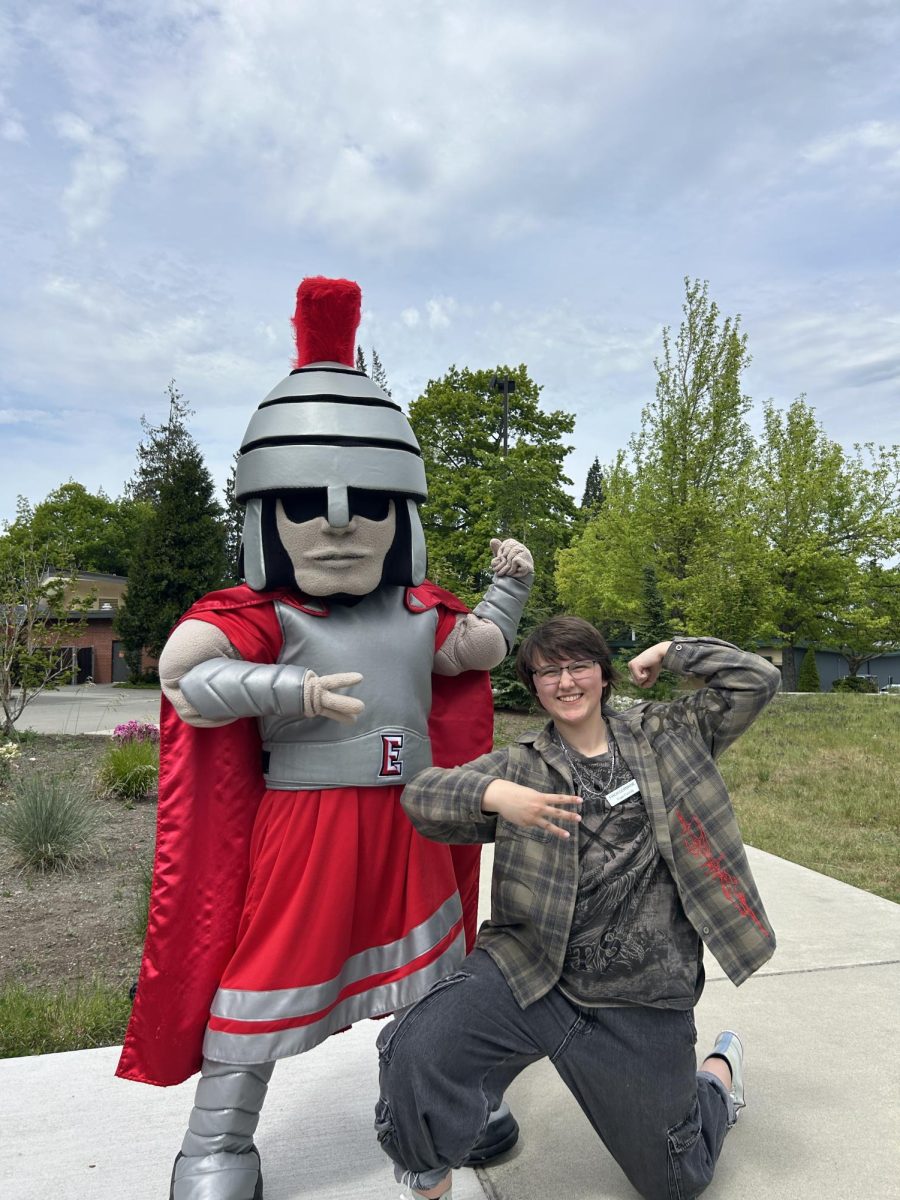 The Trojan (left) and the mascot’s handler, Finch Germaine (right) posing together. Three fingers are held up horizontally to make an “E” to enthusiastically rep EvCC.